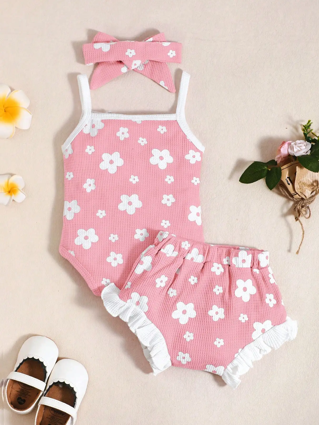 Sweet Summer Three-Piece Set for Baby Girls, Featuring a Pink Waffle-Patterned Romper with Fresh White Floral Print, Paired with Ruffled Floral Shorts and a Matching Fabric Bow Headband. the Cute Design Is Perfect for Infants and Toddlers to Wear on Daily Outings, Vacations, and Playtime.