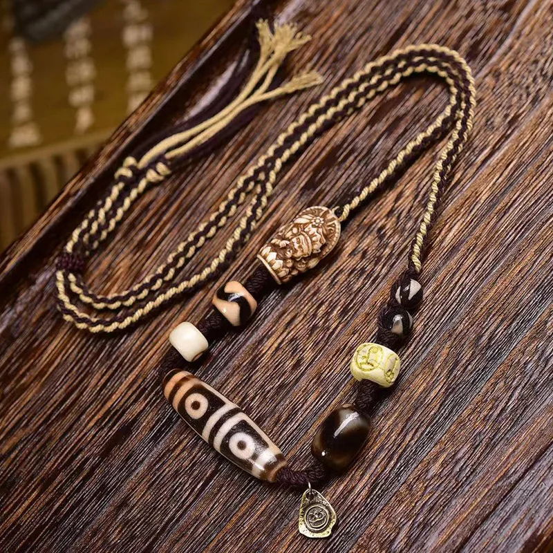 Natural agate four-eye dzi bead pendant necklace with Zaki Ram reincarnation charm and woven cord