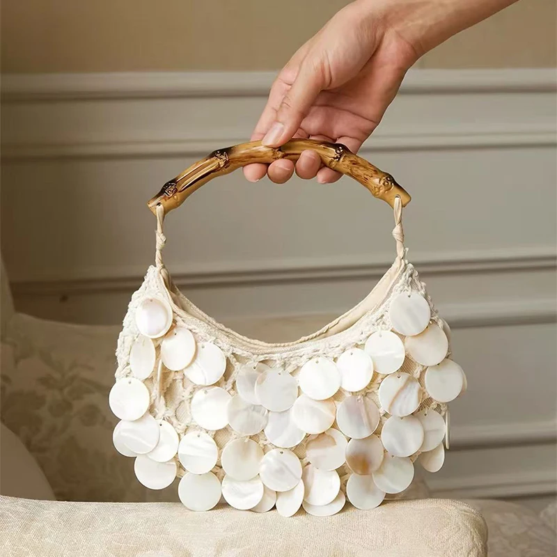 New handmade bamboo shell vacation handbag with solid color hollow weaving design and hand-held bag