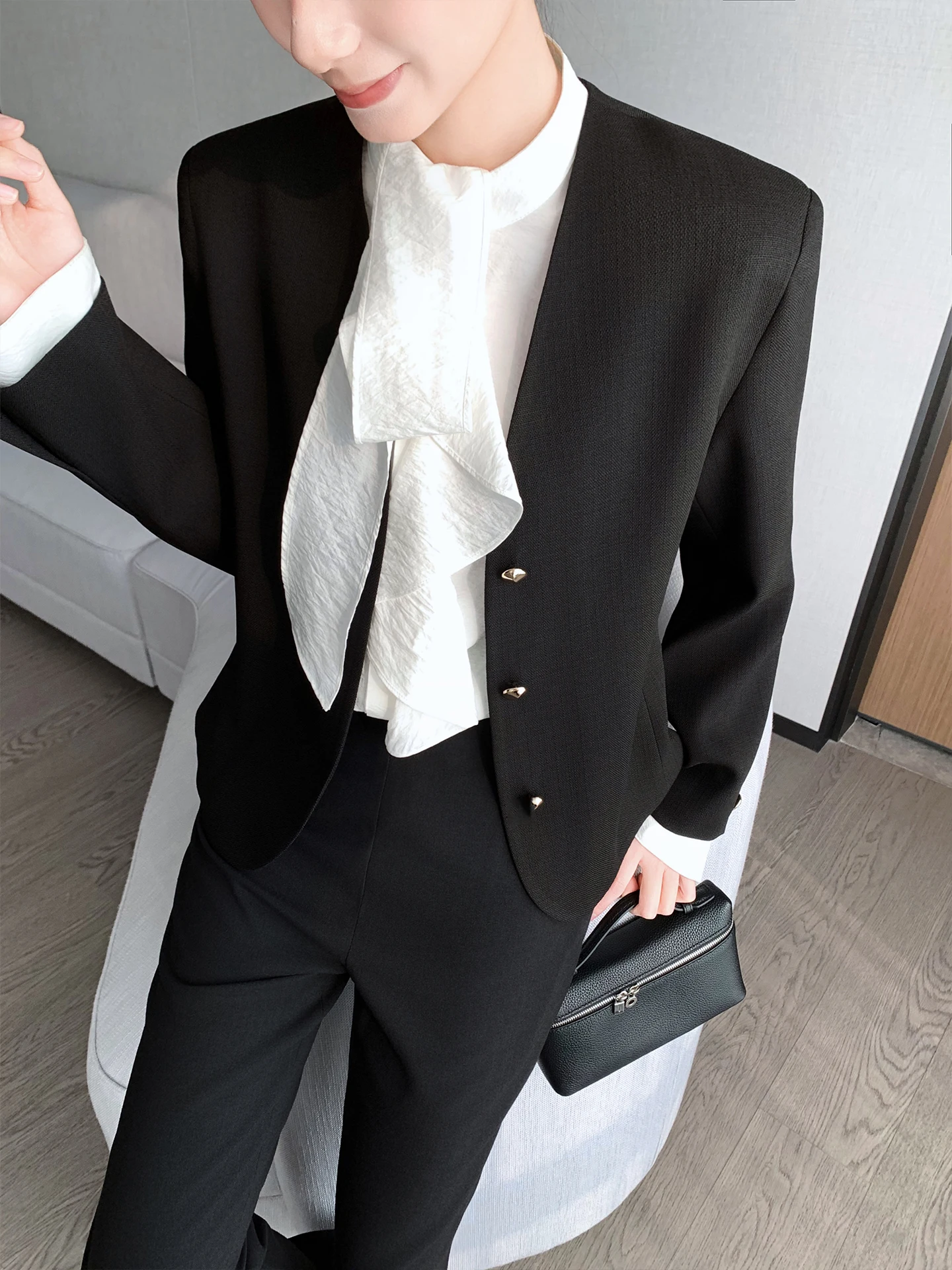 Dopasowany krój, dekolt w serek, długi rękaw, damski żakiet, czarny, z podkreśloną talią, warstwowa odzież wierzchnia, wiosna 2026, modny, uniwersalny.