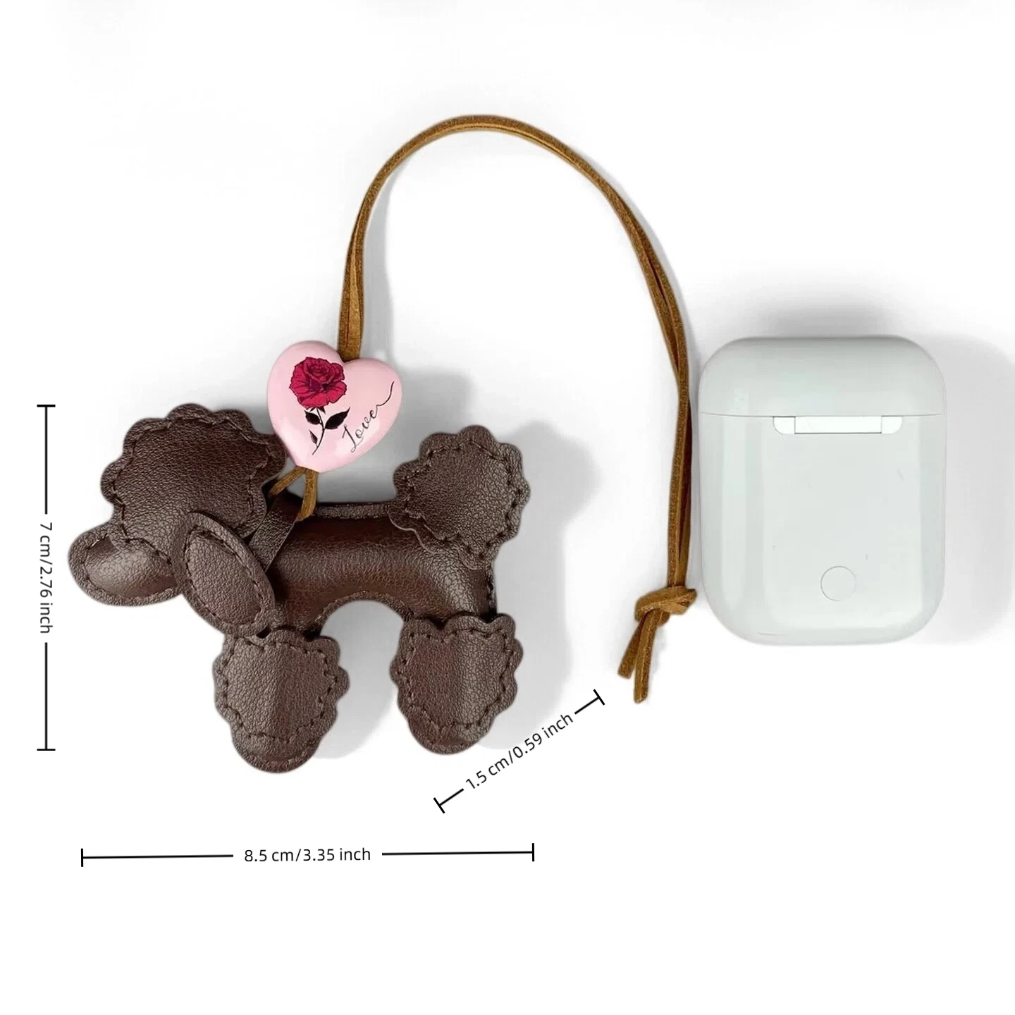 A hand holding a cluster of cute dark brown, light tan, and white PU leather poodle dog bag charms with pink heart pendants.