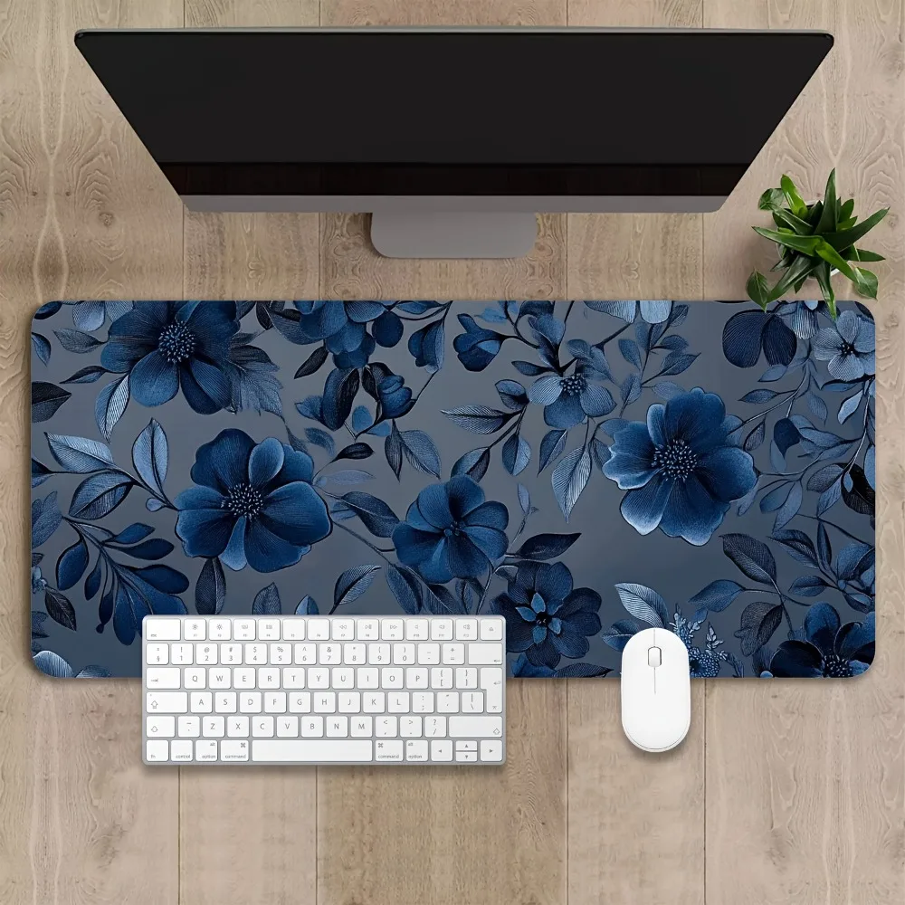 A spacious and anti-slip gaming mouse pad, featuring a blue floral and leaf design, suitable for office and gaming workstation