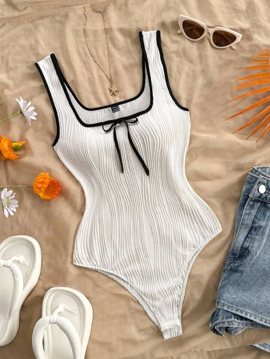 

Белое трикотажное боди в рубчик с черной отделкой и бантом спереди