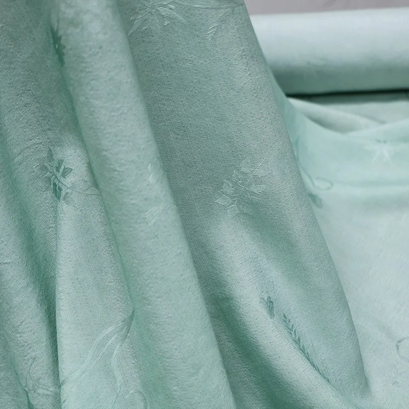 A new jacquard dirt-dyed fabric made of tussah silk with clear blue and green color from
