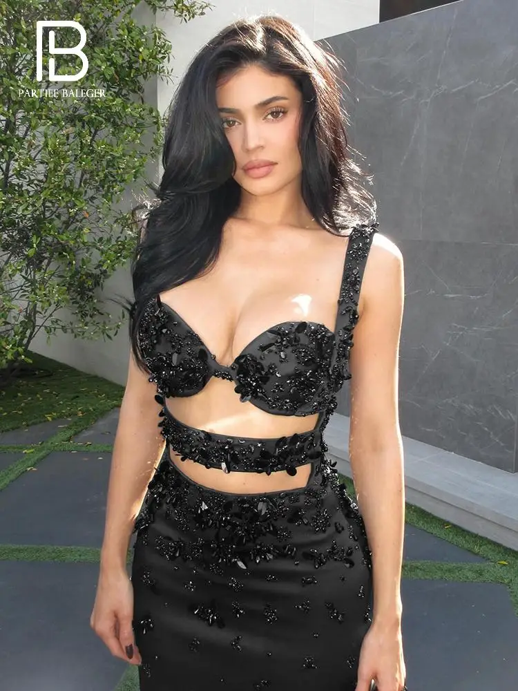 ชุดเดรสยาวสีดำประดับลูกปัดและเลื่อม พร้อมดีเทลเว้าช่วงตัว สำหรับงานกาล่าดินเนอร์สุดหรู