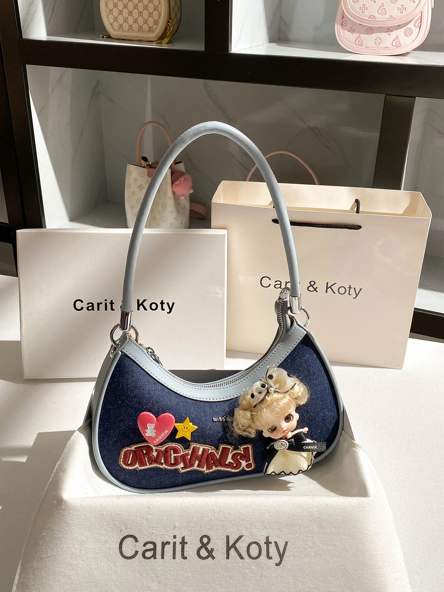 

Винтажная и роскошная сумка через плечо с милой подвеской в виде куклы. Новая мода и популярная джинсовая сумка в форме полумесяца для вечеринки.