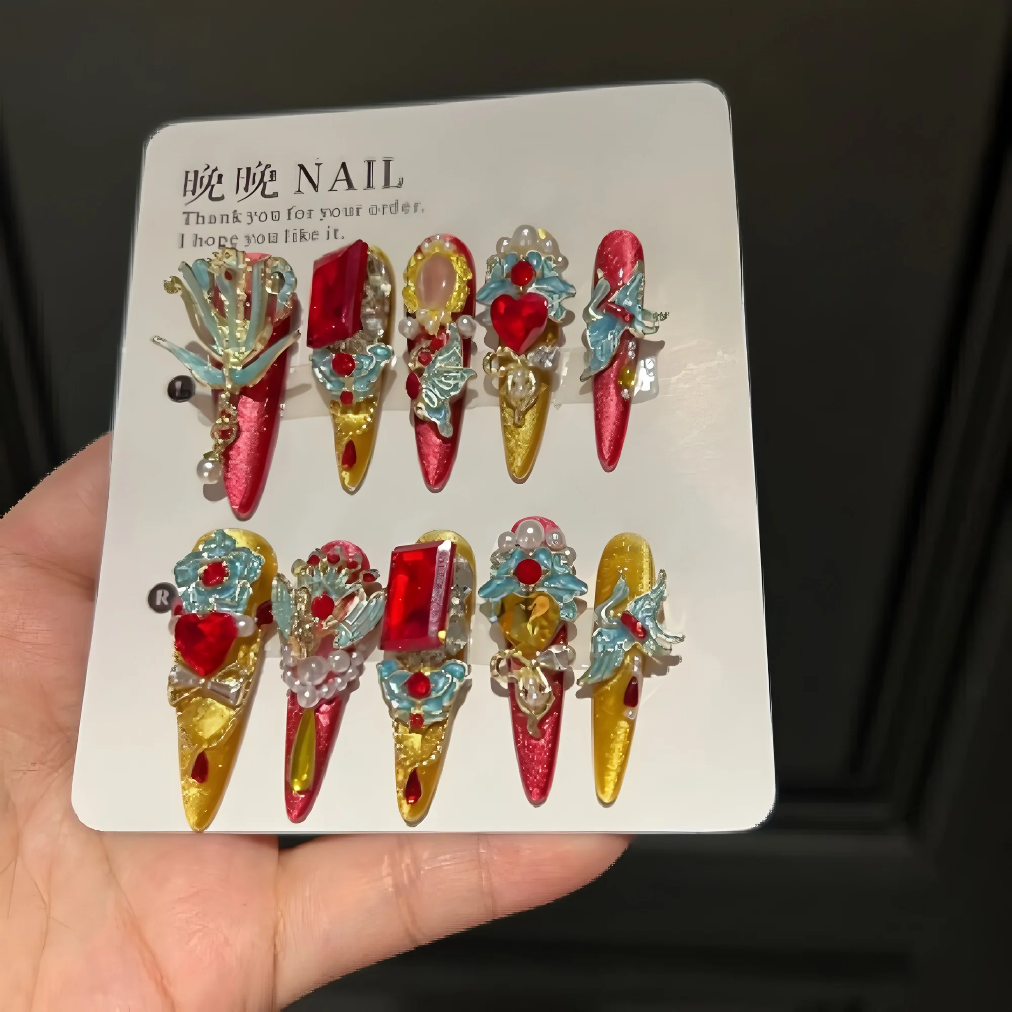 

Накладные ногти Phoenix Crown New Chinese Palace Press On Nails, очень длинные, в форме стилета, с красно-золотым градиентом, эмалью, красными кристаллами, жемчугом и бахромой.