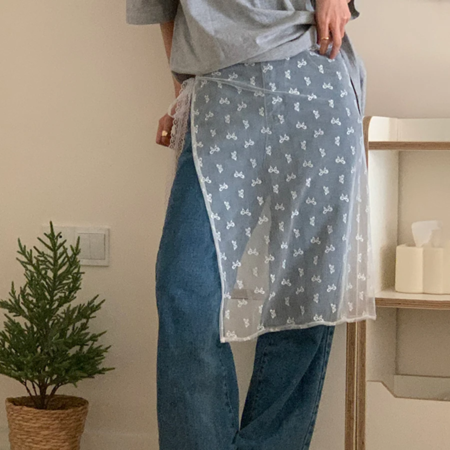 يخلق فستان الدانتيل مع غطاء الستارة مظهرًا متعدد الطبقات عند مقترن بمريلة ونصف تنورة ونمط زهور شفاف