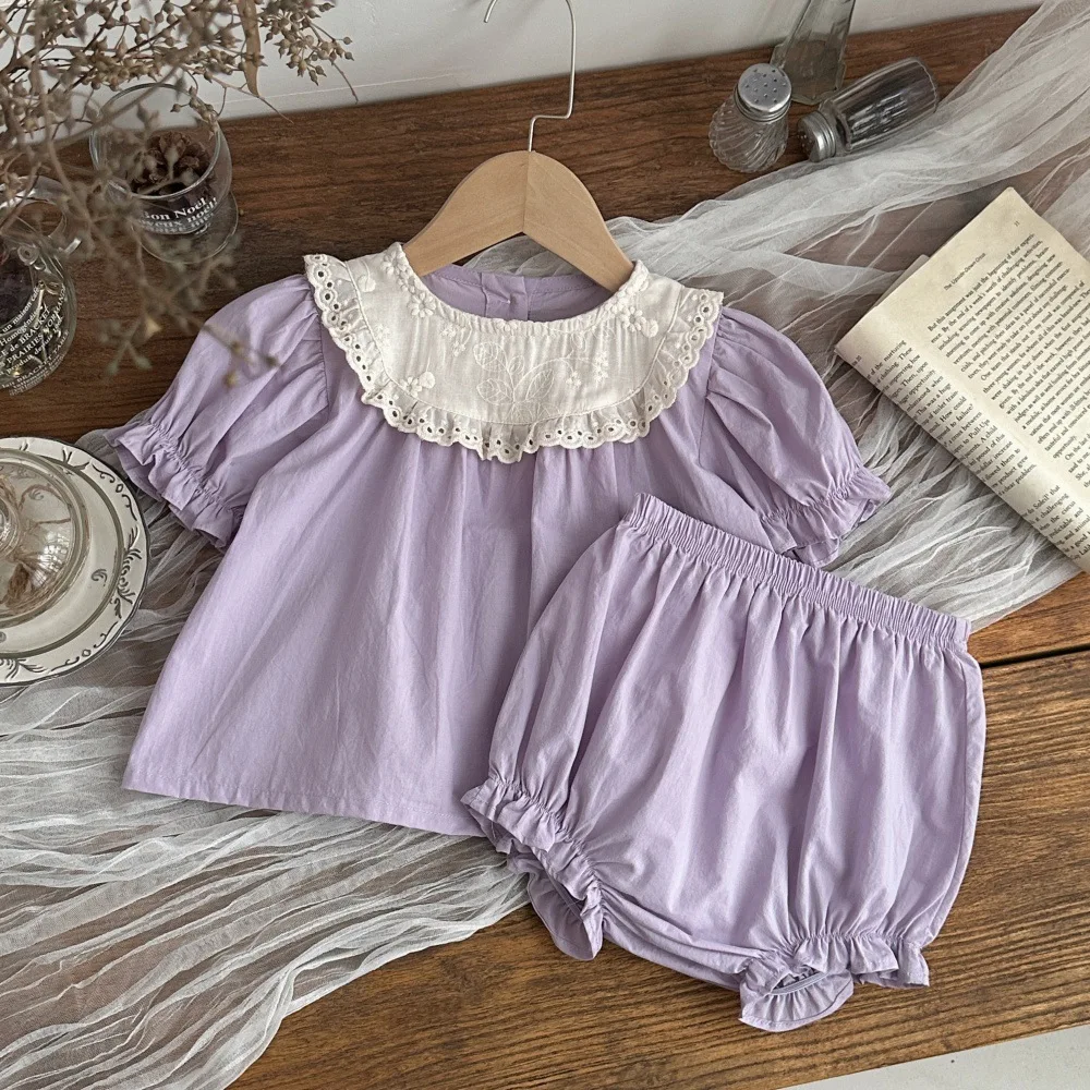 

Летний комплект одежды для девочек 2026: Новинка! Топ с коротким рукавом и кружевной вышивкой + шорты, 2 предмета. Однотонный костюм для малышей.