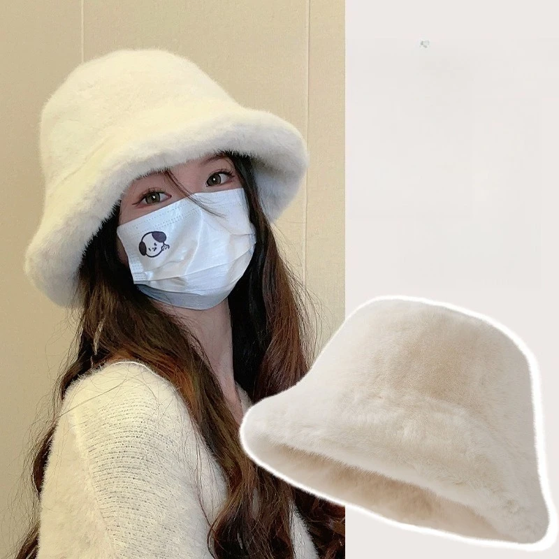 Eine weiße Wollmütze für ein süßes Mädchen im Winter, die ihr Gesicht verdickt und eine modische Mink-Fischermütze