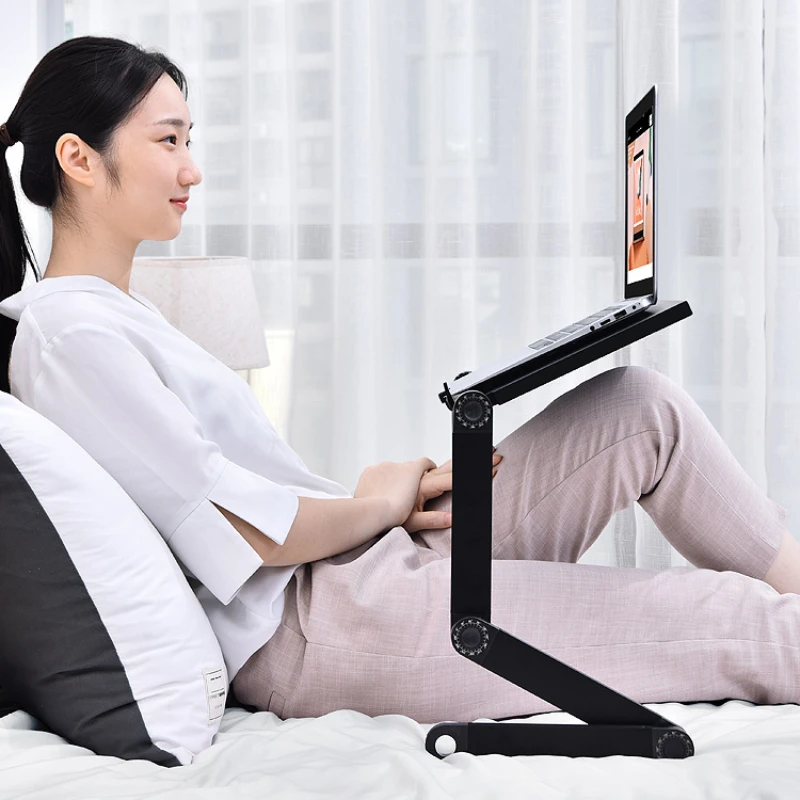 The laptop stand is lying on bed, and office stand used in flat foldable.