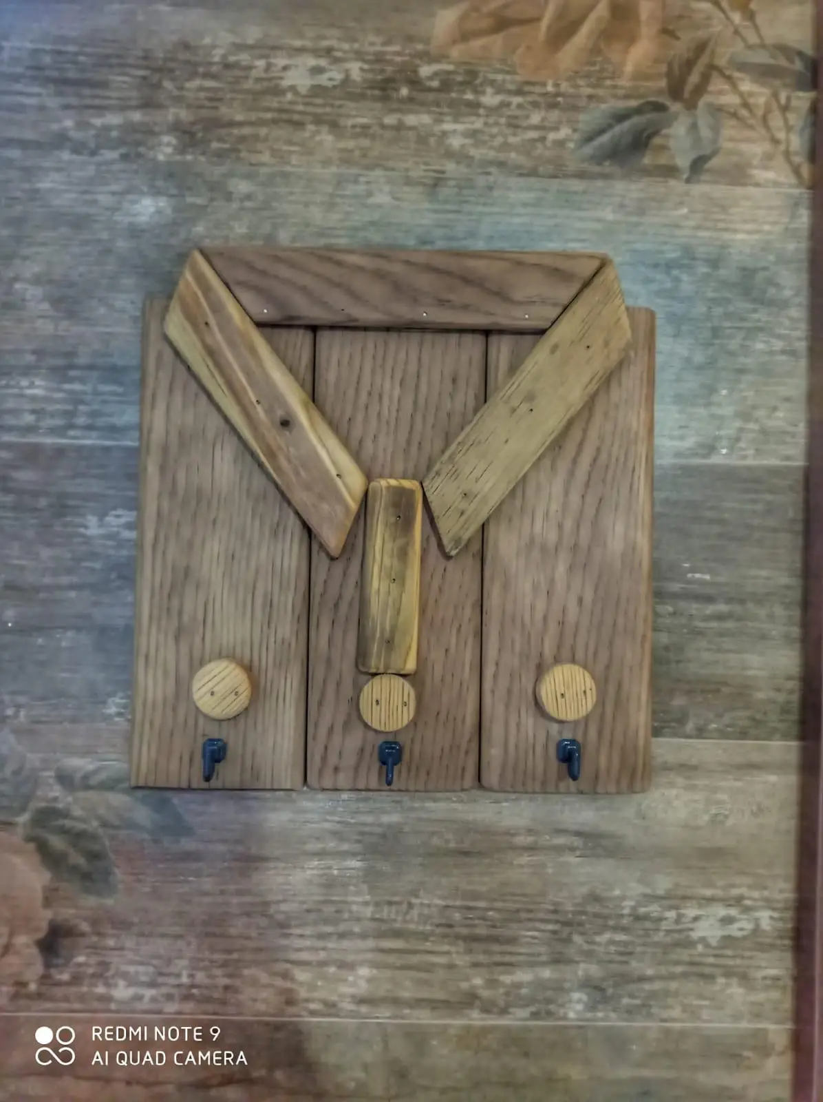 Wooden key chain with a shirt pattern.