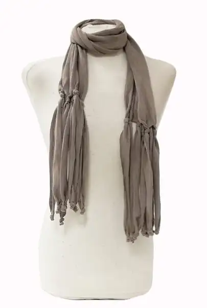 Long female scarf for young woman in light gray color. Long scarf made of knitted fabric with good ciada, original