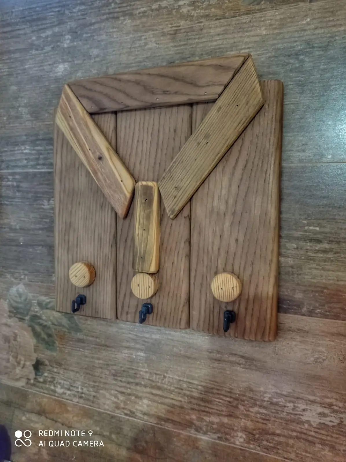 Wooden key chain with a shirt pattern.